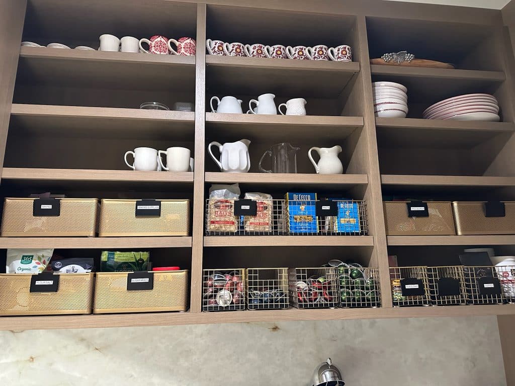 Organized pantry with neatly arranged shelves, containers, and labeled food storage